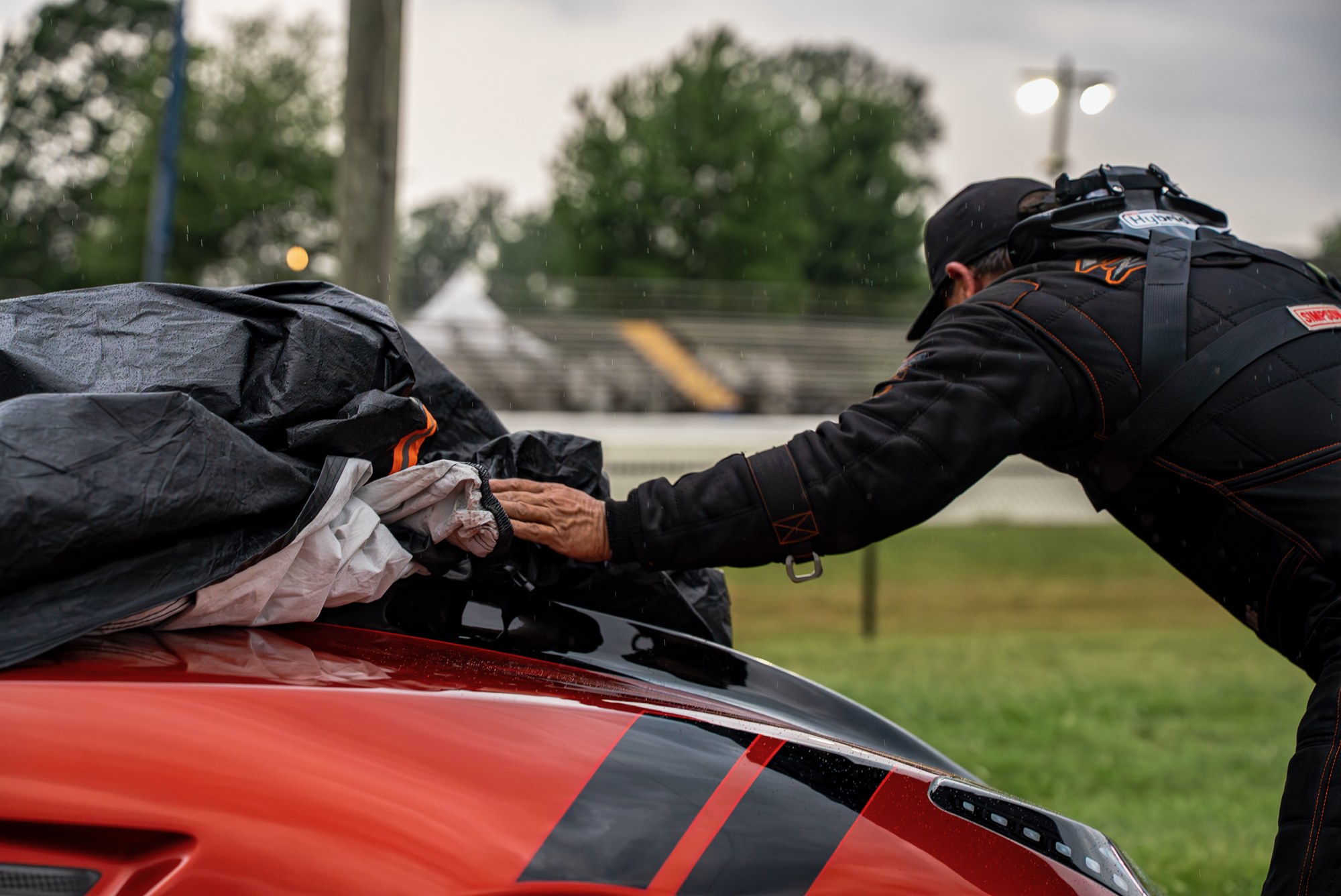 Crew member covers a Pro Mod with a tarp as rain begins to fall at IHRA Pro Mod Mania at Milan Dragway.