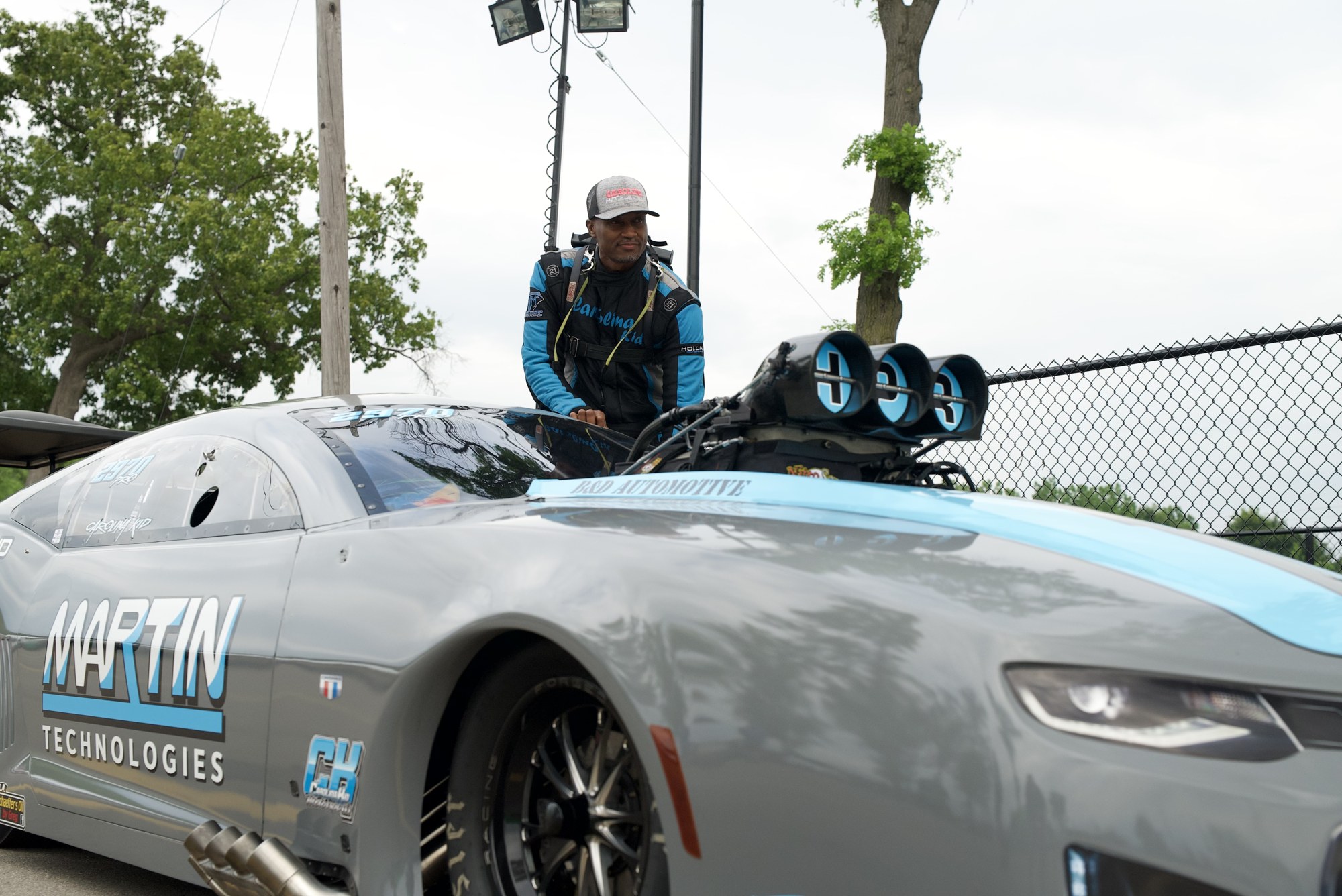 Travis Harvey suiting up next to his Pro Mod Camaro at IHRA Pro Mod Mania at Milan Dragway.