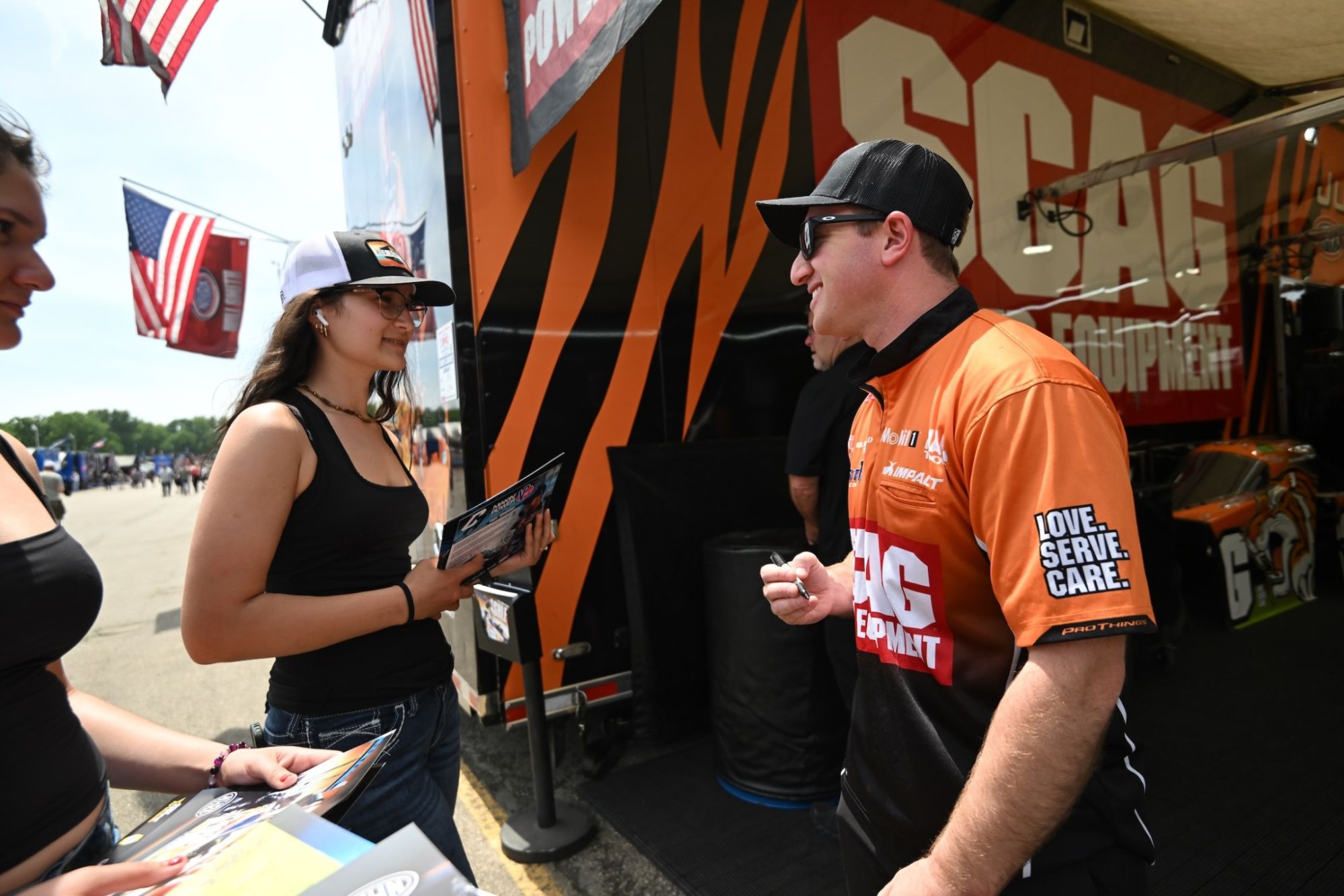 Justin Ashley signs an autograph for a fan at the NHRA New England Nationals.