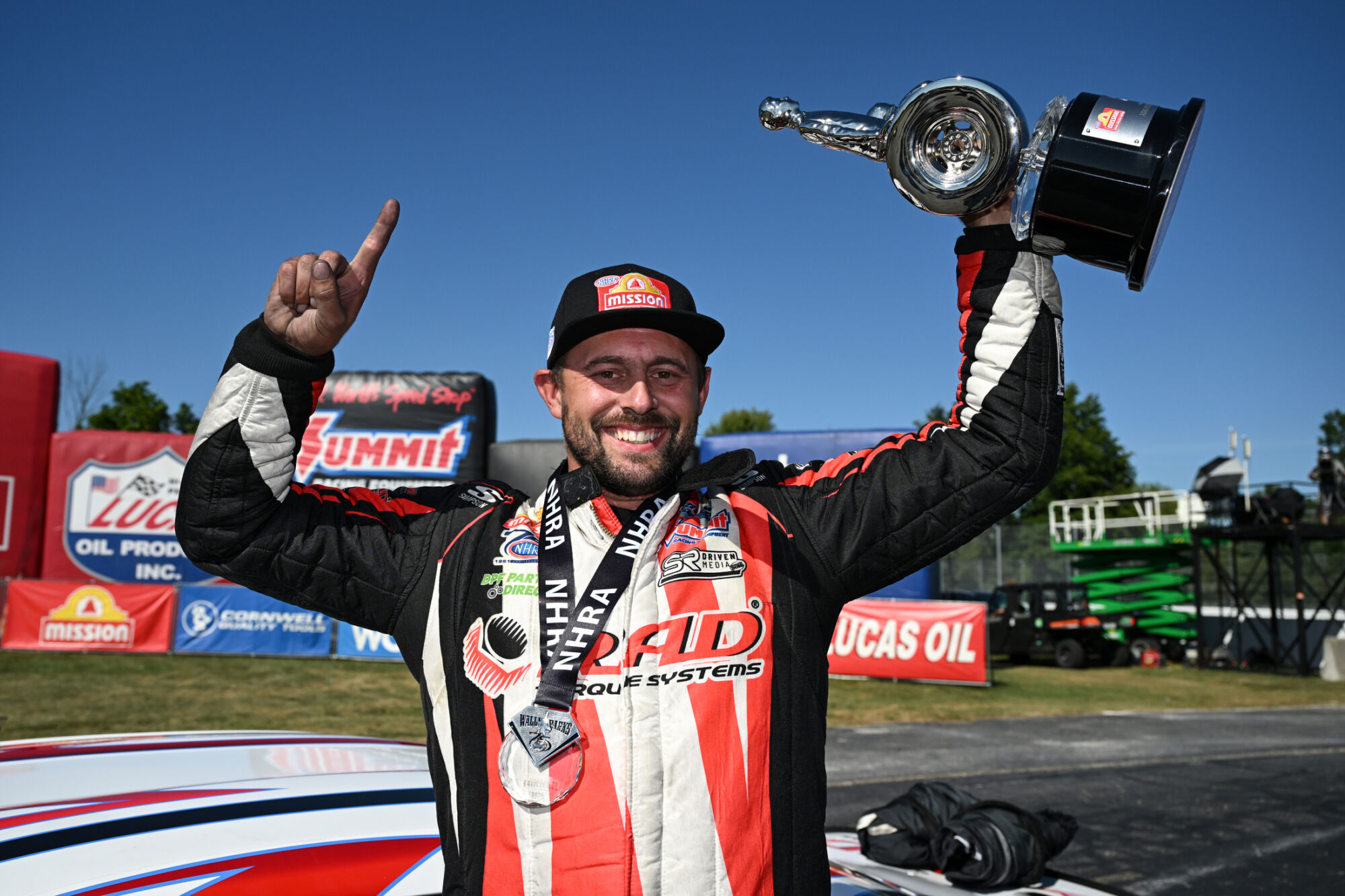 Dallas Glenn raises the Wally trophy beside the RAD Torque Systems Camaro at the 2026 NHRA U.S. Nationals