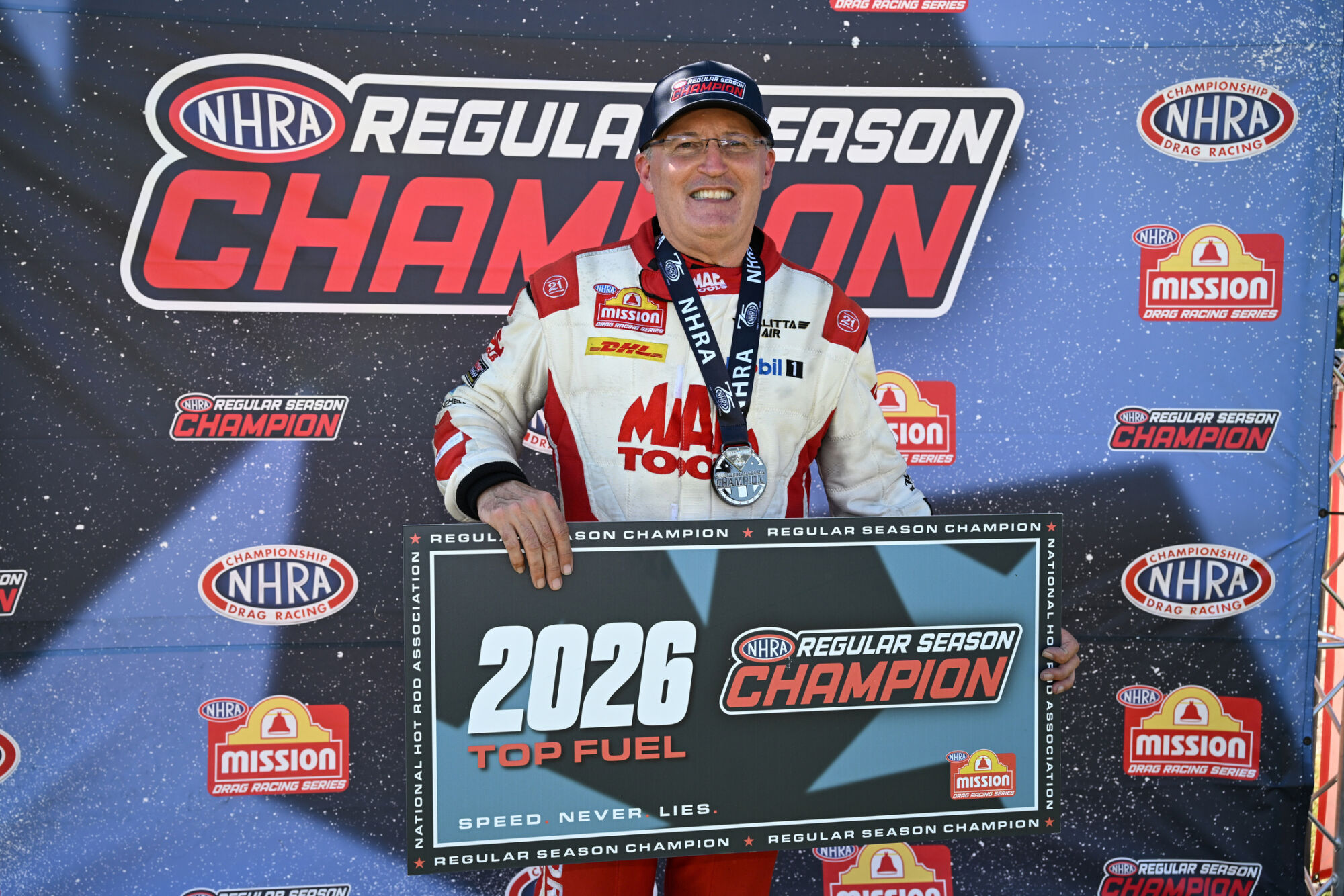 Doug Kalitta holds the 2026 NHRA Top Fuel Regular Season Champion sign at Lucas Oil Indianapolis Raceway Park