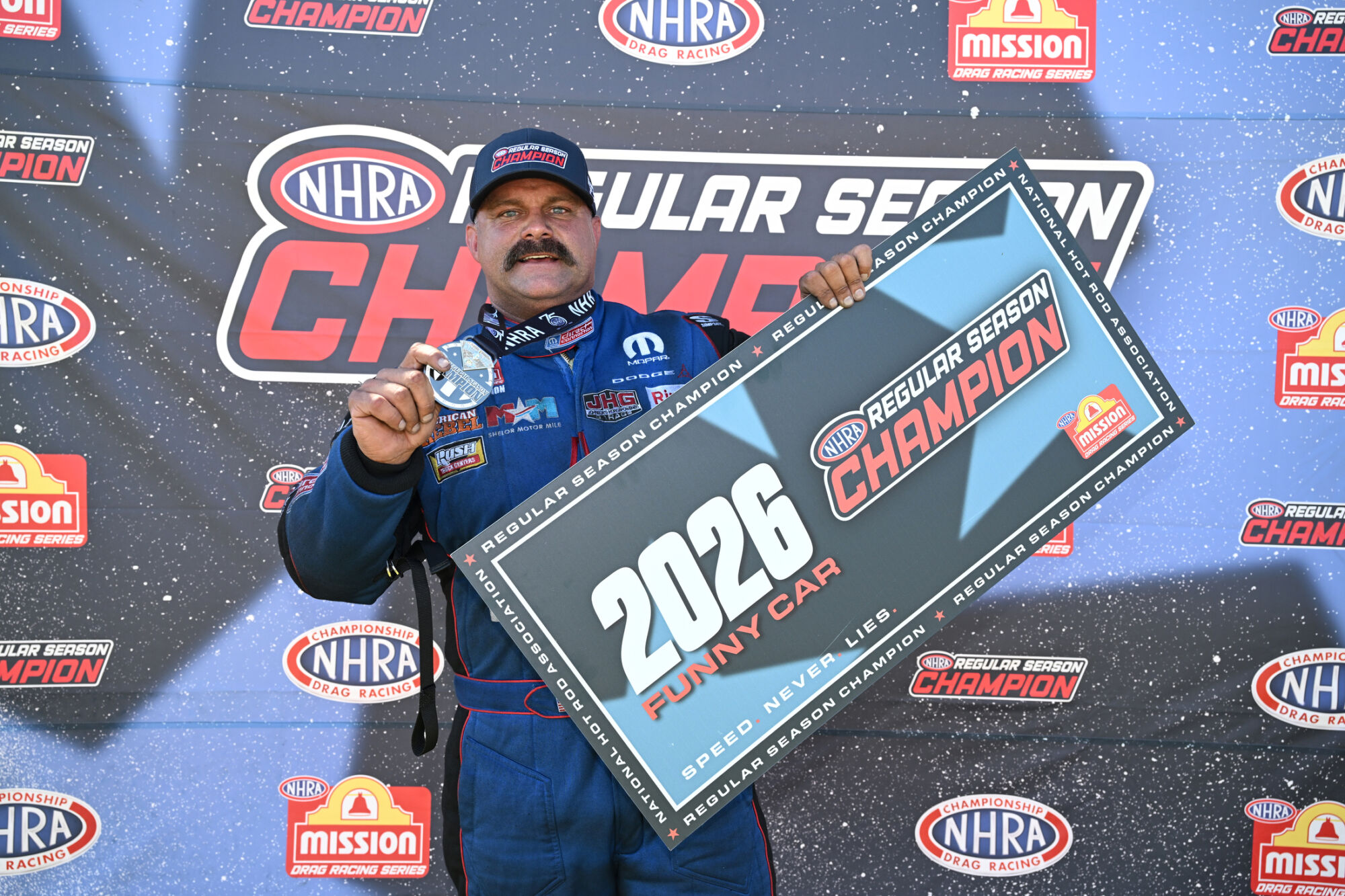 Matt Hagan holds the 2026 NHRA Funny Car Regular Season Champion sign at Lucas Oil Indianapolis Raceway Park