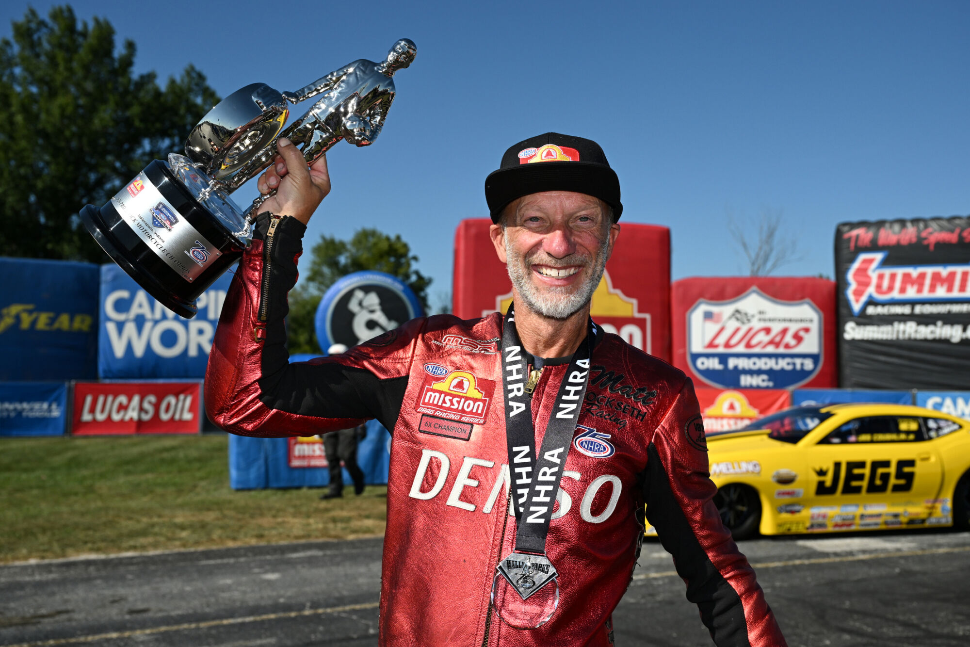 Matt Smith holds the Wally trophy in his red Denso leathers after winning Pro Stock Motorcycle at the 2026 NHRA U.S. Nationals