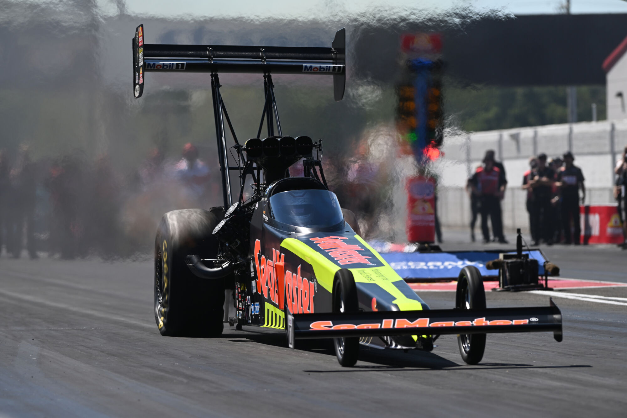 Shawn Langdon leaves the starting line in the SealMaster Top Fuel dragster with tire smoke at the 2026 NHRA U.S. Nationals