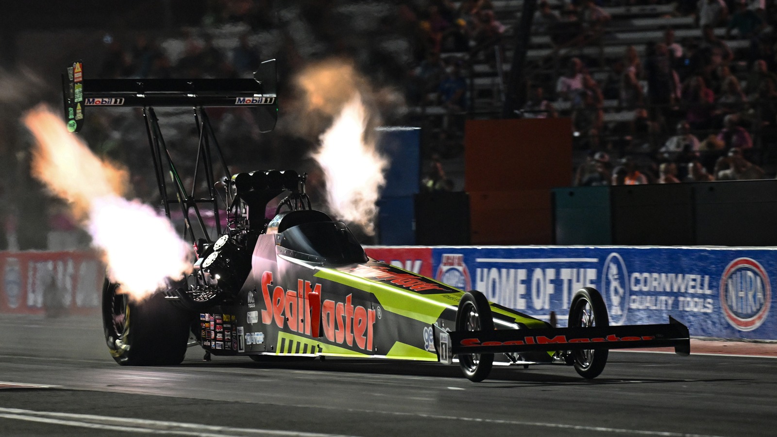 Shawn Langdon launches the SealMaster Top Fuel dragster under the lights at Indianapolis with header flames